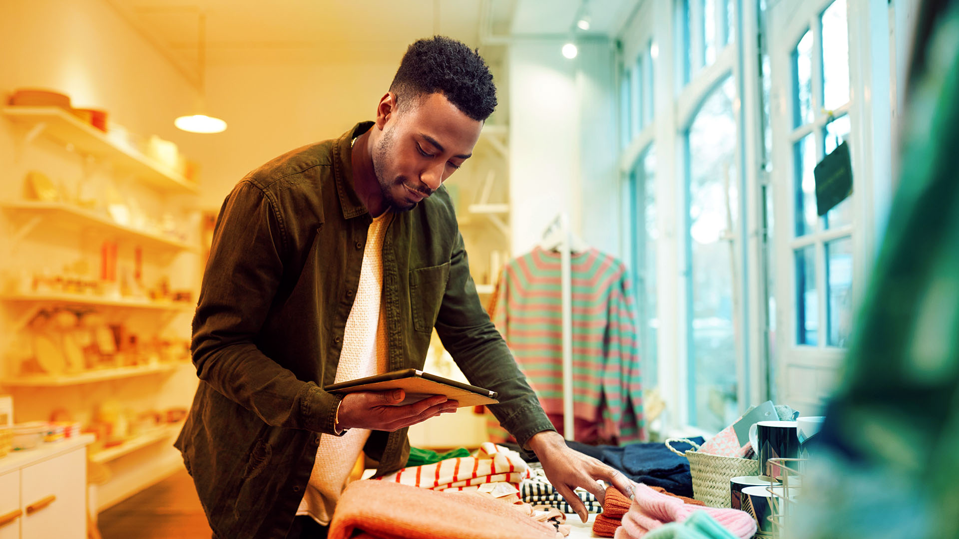 staff member takes stock in shop using tablet