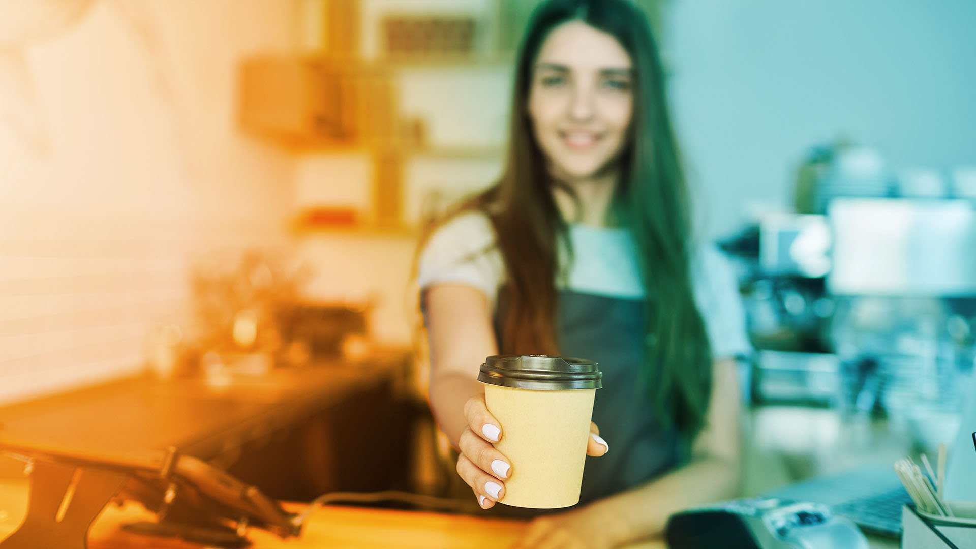 staff holding out takeout coffee